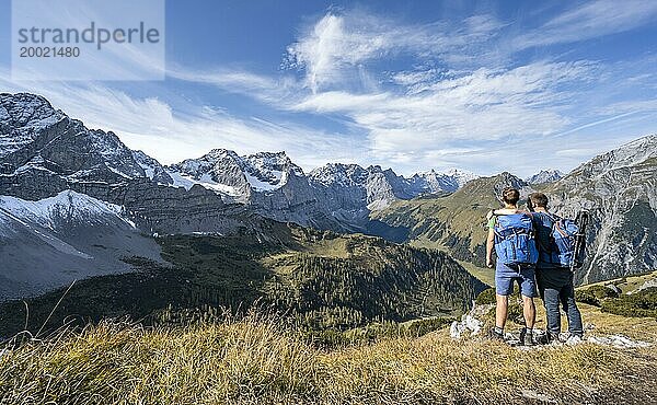 Zwei Bergsteiger  auf einem Wanderweg  Freundschaft am Berg  Bergpanorama mit felsigen steilen Gipfeln  Ausblick auf Gipfel Laliderspitze  Dreizinkenspitze und Spritzkarspitze  Wanderung zum Gipfel des Hahnkampl  Engtal  Karwendel  Tirol  Österreich  Europa
