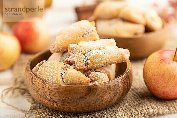 Hausgemachte süße Kekse mit Apfelmarmelade und Tasse Kaffee auf weißem hölzernem Hintergrund und Leinenstoff. Seitenansicht  Nahaufnahme  selektiver Fokus