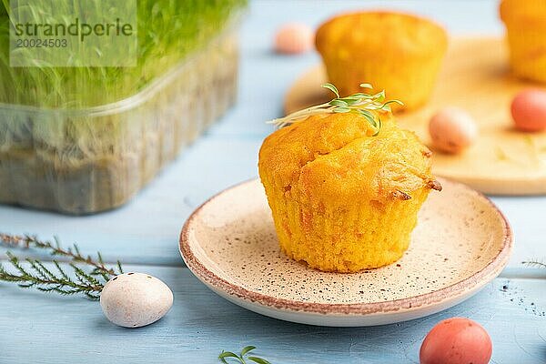 Hausgemachte Kuchen mit Schokoladeneiern und Karotte microgreen auf einem blaün hölzernen Hintergrund. Seitenansicht  Nahaufnahme  selektiver Fokus