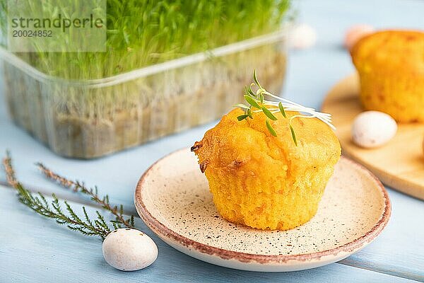 Hausgemachte Kuchen mit Schokoladeneiern und Karotte microgreen auf einem blauen hölzernen Hintergrund. Seitenansicht  Nahaufnahme  selektiver Fokus