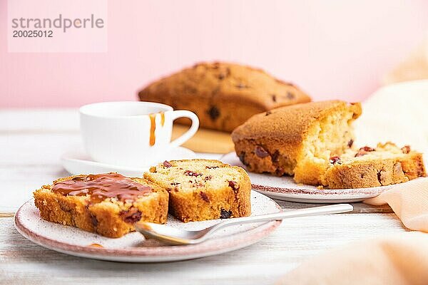 Hausgemachter Kuchen mit Rosinen  Mandeln  weichem Karamell auf einem weißen und rosa Hintergrund. Seitenansicht  Nahaufnahme  selektiver Fokus