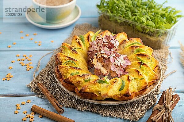 Käsekuchen mit Tasse Kaffee und Mikrogrün auf blauem Holzhintergrund und Leinenstoff. Seitenansicht  Nahaufnahme  selektiver Fokus