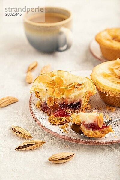 Traditionelle portugiesische Kuchen pasteis de nata  Pudding kleine Kuchen mit Mandeln mit Tasse Kaffee auf grauem Beton Hintergrund. Seitenansicht  Nahaufnahme  selektiver Fokus