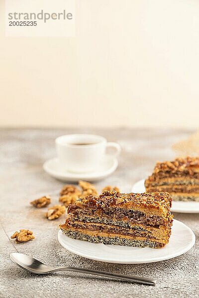 Walnuss und Haselnusskuchen mit Karamellcreme  Tasse Kaffee auf braunem Betonhintergrund. Seitenansicht  selektiver Fokus