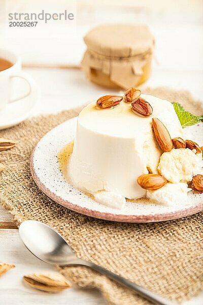 Ricotta Käse mit Honig und Mandeln auf weißem Holzhintergrund und Leinenstoff. Seitenansicht  Nahaufnahme  selektiver Fokus