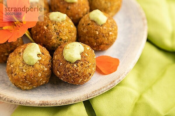 Falafel mit Guacamole auf weißem Betonhintergrund und grünem Leinentuch. Seitenansicht  Nahaufnahme  selektiver Fokus