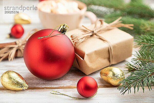 Weihnachten oder Neujahr Zusammensetzung. Dekorationen  Box  rote Kugeln  Zimt  Tanne und Fichte Zweige  Tasse Kaffee  auf einem weißen hölzernen Hintergrund. Seitenansicht  Nahaufnahme  selektiver Fokus