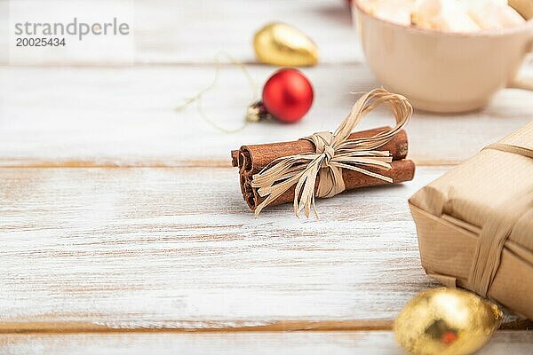 Weihnachten oder Neujahr Zusammensetzung. Dekorationen  Box  rote Kugeln  Zimt  Tannen und Fichtenzweige  Tasse Kaffee  auf einem weißen Holzhintergrund. Seitenansicht  Kopierraum  selektiver Fokus