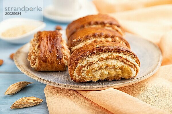 Traditionelles armenisches Dessert Gata mit einer Tasse Kaffee auf einem blaün hölzernen Hintergrund und orangefarbenem Leinenstoff. Seitenansicht  Nahaufnahme  selektiver Fokus