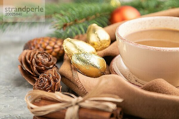 Weihnachten oder Neujahr Zusammensetzung. Dekorationen  Zapfen  Zimt  Tannen und Fichtenzweige  Tasse Kaffee  Wollschal auf einem grauen Betonhintergrund. Seitenansicht  Nahaufnahme  selektiver Fokus