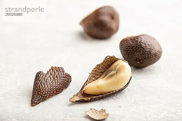 Salak oder Schlangenfrucht auf grauem Betonhintergrund. Seitenansicht  Nahaufnahme  selektiver Fokus. Tropisch  gesunde Ernährung  Sommer  exotisch  Minimalismus