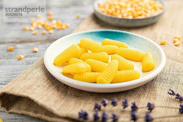 Jelly Corn Bonbons auf grauem hölzernen Hintergrund und Leinen Textil. Nahaufnahme  Seitenansicht  selektiver Fokus