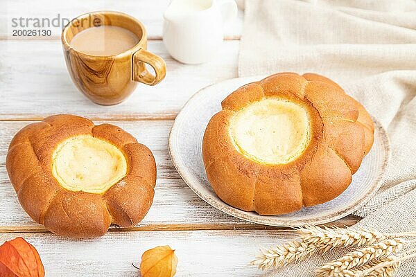 Saures Sahnebrötchen mit Tasse Kaffee auf weißem Holzhintergrund und Leinenstoff. Seitenansicht  Nahaufnahme  selektiver Fokus