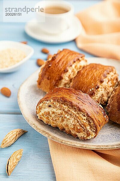 Traditionelles armenisches Dessert Gata mit einer Tasse Kaffee auf einem blauen hölzernen Hintergrund und orangefarbenem Leinenstoff. Seitenansicht  Nahaufnahme  selektiver Fokus