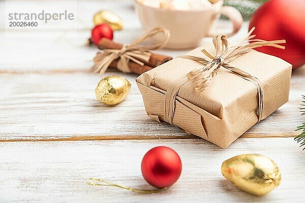 Weihnachten oder Neujahr Zusammensetzung. Dekorationen  Box  rote Kugeln  Zimt  Tannen und Fichtenzweige  Tasse Kaffee  auf einem weißen Holzhintergrund. Seitenansicht  Kopierraum  selektiver Fokus