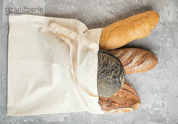 Wiederverwendbare Textil Lebensmittel Tasche mit frisch gebackenem Brot auf einem grauen Beton Hintergrund. Draufsicht  flat lay  copy space. zero waste concept