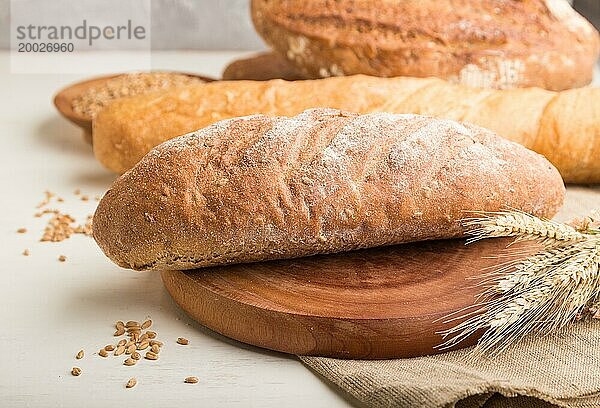 Verschiedene Arten von frisch gebackenem Brot auf einem weißen hölzernen Hintergrund. Seitenansicht  Nahaufnahme  selektiver Fokus