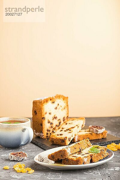 Hausgemachter Kuchen mit Rosinen  getrockneten Kaki und einer Tasse heißer Schokolade auf einem schwarz orangen Hintergrund. Seitenansicht  Nahaufnahme  Kopierraum  selektiver Fokus