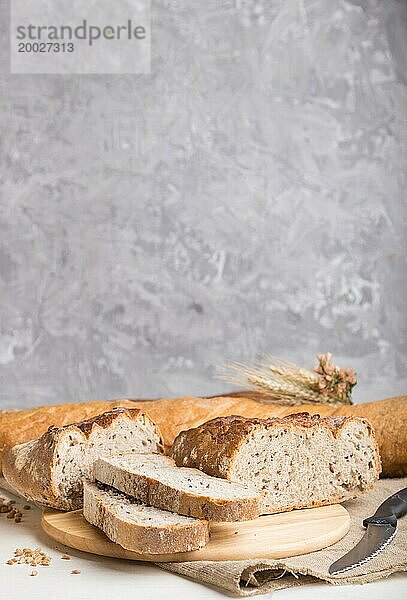 Aufgeschnittenes Brot mit verschiedenen Arten von frisch gebackenem Brot auf einem grauen Betonhintergrund. Seitenansicht  Nahaufnahme  selektiver Fokus