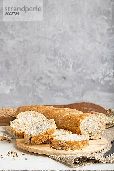 Aufgeschnittenes Brot mit verschiedenen Arten von frisch gebackenem Brot auf einem grauen Betonhintergrund. Seitenansicht  Nahaufnahme  selektiver Fokus