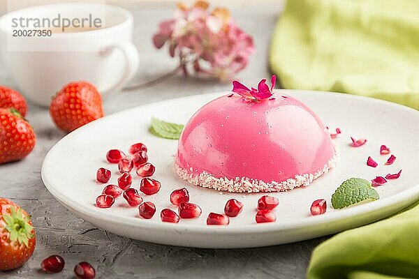 Rosa Mousse Torte mit Erdbeeren und einer Tasse Kaffee auf einem grauen Betonhintergrund und grünem Textil. Seitenansicht  Nahaufnahme  selektiver Fokus