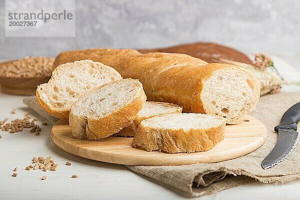 Aufgeschnittenes Brot mit verschiedenen Arten von frisch gebackenem Brot auf weißem Holzhintergrund. Seitenansicht  Nahaufnahme  selektiver Fokus