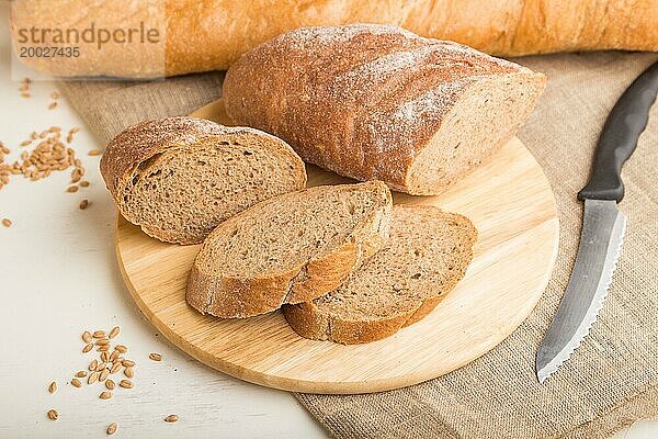 Aufgeschnittenes Brot mit verschiedenen Arten von frisch gebackenem Brot auf weißem Holzhintergrund. Seitenansicht  Nahaufnahme  selektiver Fokus