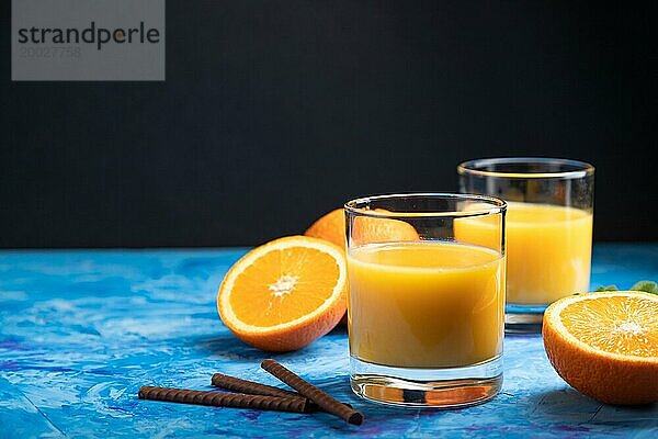 Glas Orangensaft auf einem schwarzen und blaün Hintergrund. Hartes Licht  Kontrast. Seitenansicht  Kopierraum