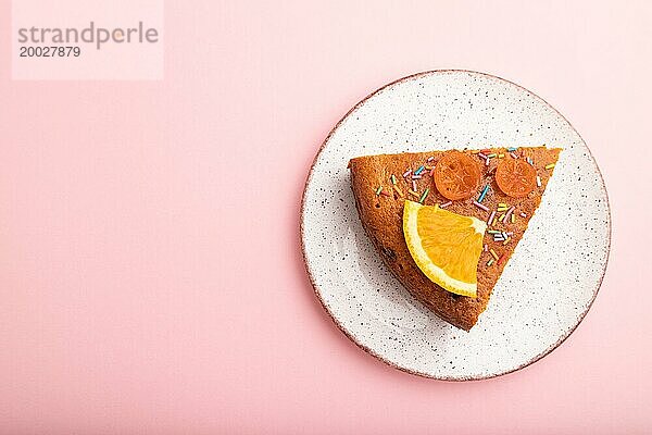 Ein Stück orangefarbener Kuchen auf einem pastellrosa Hintergrund. Draufsicht  flat lay  copy space