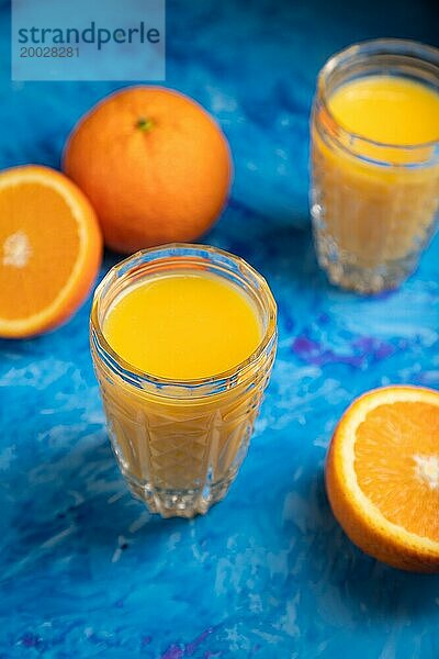 Glas Orangensaft auf einem schwarzen und blaün Hintergrund. Hartes Licht  Kontrast. Seitenansicht  Nahaufnahme