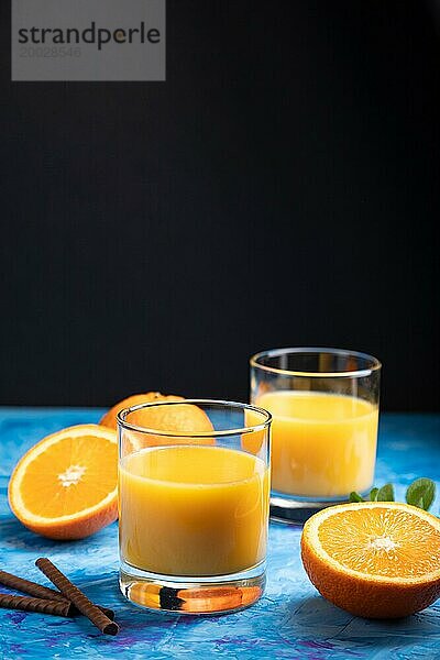 Glas Orangensaft auf einem schwarzen und blaün Hintergrund. Hartes Licht  Kontrast. Seitenansicht  Kopierraum