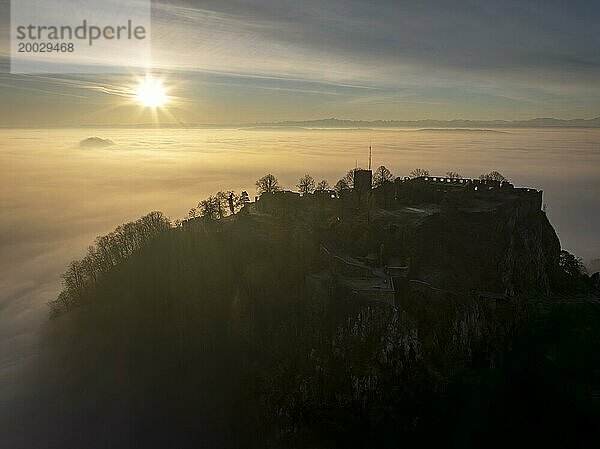 Luftbild vom Hegauvulkan Hohentwiel mit der oberen Festungsruine als Silhouette bei Sonnenaufgang  die bei einer Inversionswetterlage aus dem Nebel herausragt  Landkreis Konstanz  Baden-Württemberg  Deutschland  Europa