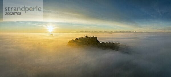 Luftbild vom Hegauvulkan Hohentwiel mit der oberen Festungsruine als Silhouette bei Sonnenaufgang  die bei einer Inversionswetterlage aus dem Nebel herausragt  Landkreis Konstanz  Baden-Württemberg  Deutschland  Europa