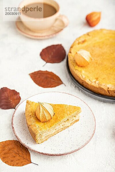 Herbst Zwiebelkuchen mit Blättern und Tasse Kaffee auf grauem Beton Hintergrund dekoriert. Seitenansicht  Nahaufnahme  selektiver Fokus