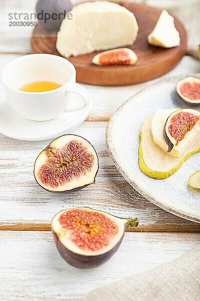 Sommerliche Vorspeise mit Birne  Hüttenkäse  Feigen und Honig auf einem weißen Holzhintergrund und Leinenstoff. Seitenansicht  Nahaufnahme  selektiver Fokus