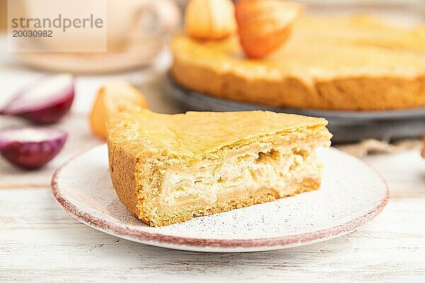 Herbstlicher Zwiebelkuchen und Tasse Kaffee auf weißem Holzhintergrund und Leinentextil. Seitenansicht  Nahaufnahme  selektiver Fokus