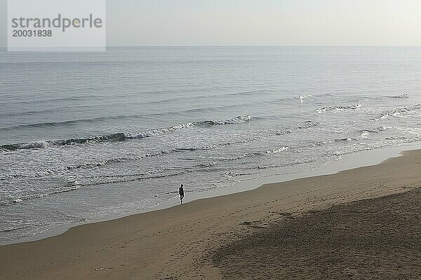 Frauensilhouette  die allein am Strand entlang geht  Bellreguard  in der Nähe von Gandia  Provinz Valencia  Spanien  Europa