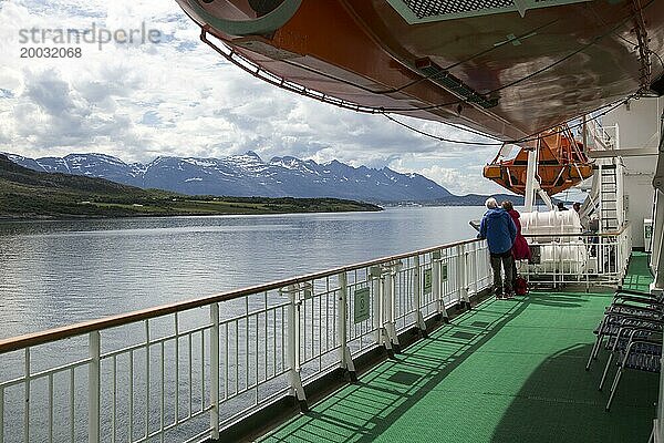 Zwei Personen an Deck mit Blick auf die Landschaft auf dem Hurtigruten Fährschiff  nahe der Polarkreisüberquerung  Norwegen  Europa