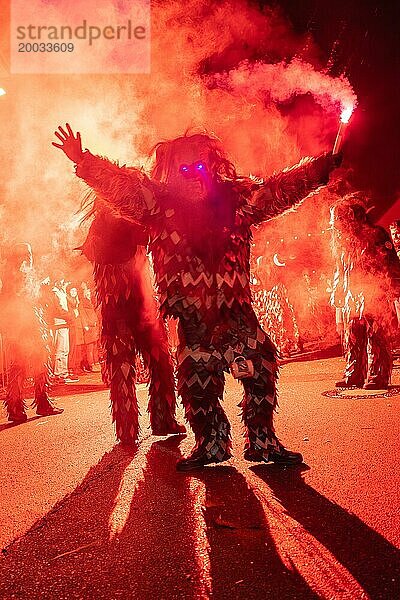 Person in einem beleuchteten Kostüm steht im Rauch bei einer nächtlichen Feier  Fasching  Schellbronner Nachtumzug  Schellbronn  Deutschland  Europa