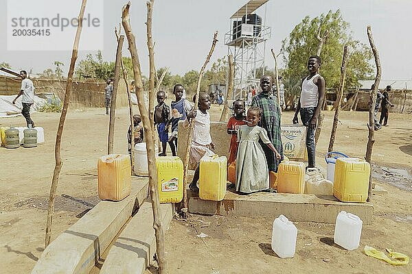 Kinder und Erwachsene stehen mir Wasserkanistern an einem Brunnen in der Gorom Flüchtlingssiedlung südwestlich von Dschuba  26.01.2024. / Fotografiert im Auftrag des Auswärtigen Amtes