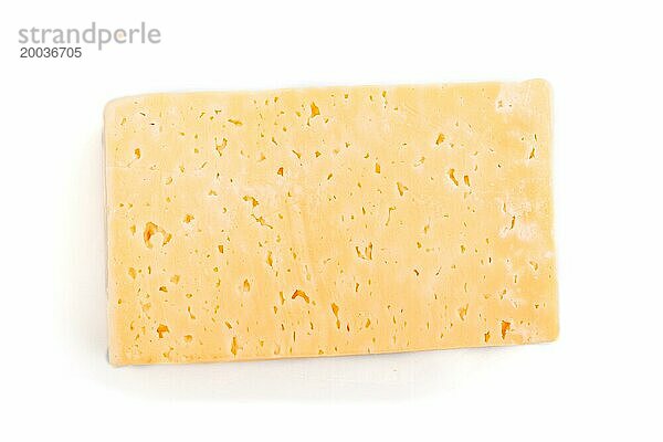 Ein Stück gelber Käse vor weißem Hintergrund. Draufsicht  Nahaufnahme