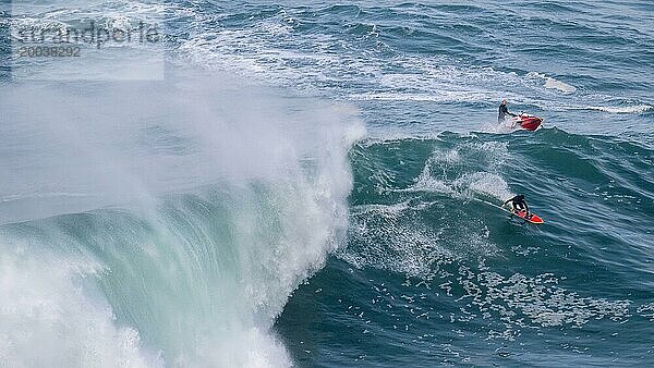 Ein Surfer und ein Jetski auf einer großen Welle  Nazaré  Portugal  Europa