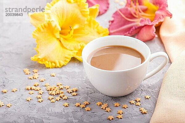 Gelbe und lila Taglilien Tasse Kaffee auf einem grauen Hintergrund Beton  mit orangefarbenen Textil. Morninig  Frühling  Mode Zusammensetzung  Seitenansicht  Nahaufnahme  selektiver Fokus