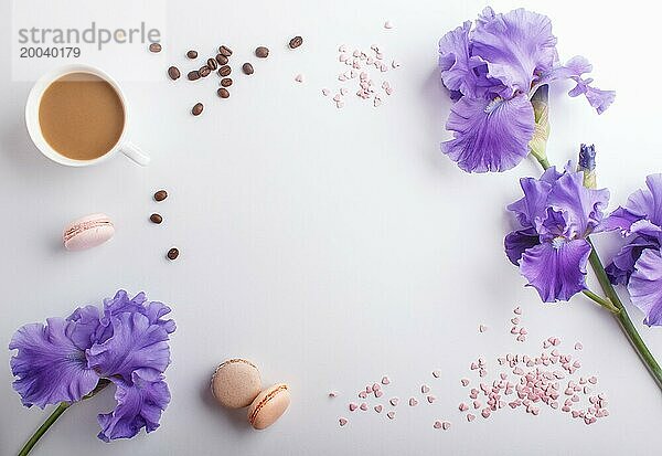 Lila Irisblüten und eine Tasse Kaffee auf einem weißen Hintergrund. Morninig  Frühling  Mode Zusammensetzung. Flachlage  Draufsicht  Kopierraum