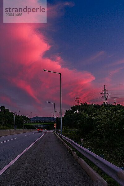 Blauer Himmel mit großen rosa Wolken über der Autobahn zur blauen Stunde in Südkorea