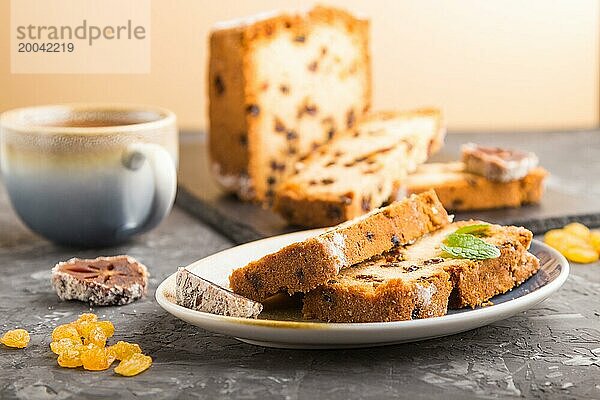 Hausgemachter Kuchen mit Rosinen  getrockneten Kaki und einer Tasse heißer Schokolade auf einem schwarzen Betonhintergrund. Seitenansicht  Nahaufnahme  Kopierraum  selektiver Fokus