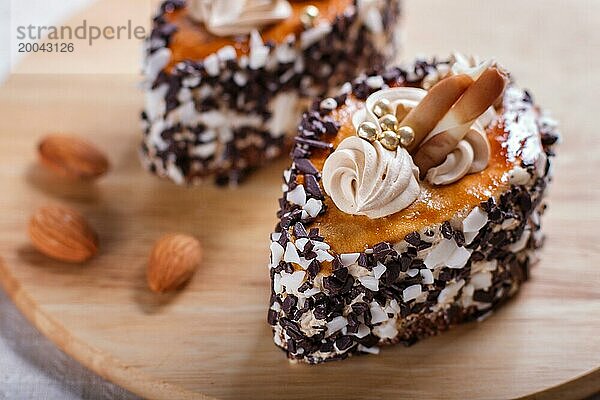 Kuchen mit Schokoladenstückchen und Sahne Dekorationen auf Holzbrett auf weißem Hintergrund. selektiven Fokus  Nahaufnahme