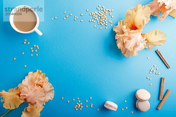 Orangefarbene Irisblüten und eine Tasse Kaffee auf einem blaün pastellfarbenen Hintergrund. Morninig  Frühling  Mode Zusammensetzung. Flachlage  Draufsicht  Kopierraum