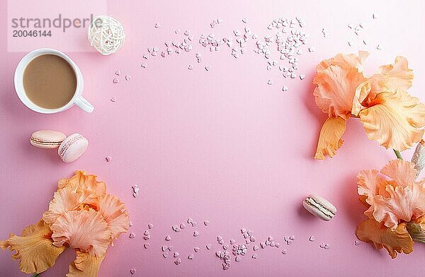 Orangefarbene Irisblüten und eine Tasse Kaffee auf einem rosa pastellfarbenen Hintergrund. Morninig  Frühling  Mode Zusammensetzung. Flachlage  Draufsicht  Kopierraum