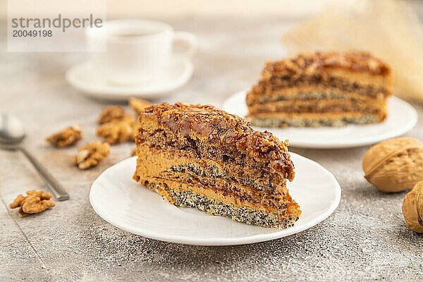 Walnuss und Haselnusskuchen mit Karamellcreme  Tasse Kaffee auf braunem Betonhintergrund. Seitenansicht  selektiver Fokus